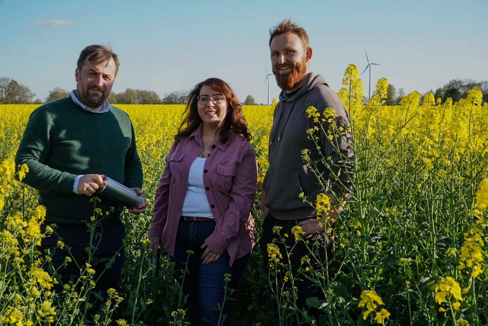 Manuela und Christian mit einem Landwirt im Rapsfeld